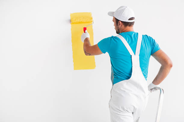 istock Painter painting wall in yellow color 1302538538