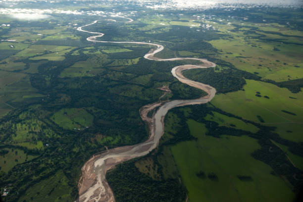 widok z lotu ptaka na rzekę z polem uprawnym wokół niej o zmierzchu. kolumbia. - lag zdjęcia i obrazy z banku zdjęć