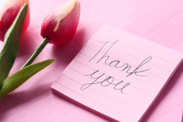 istock thank you message on sticky note with tulip flower on pink background 1302542778