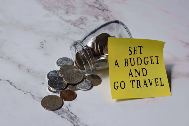 text on yellow notepad stick on a jar with chinese yuan coin on the white table surface - set a budget and go travel - investment rmb savings china imagens e fotografias de stock