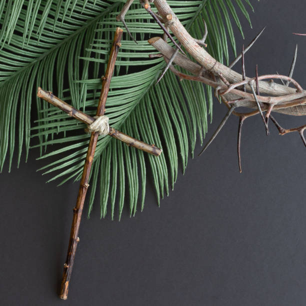 istock Crown of thorns, cross and palms on black 1302543879