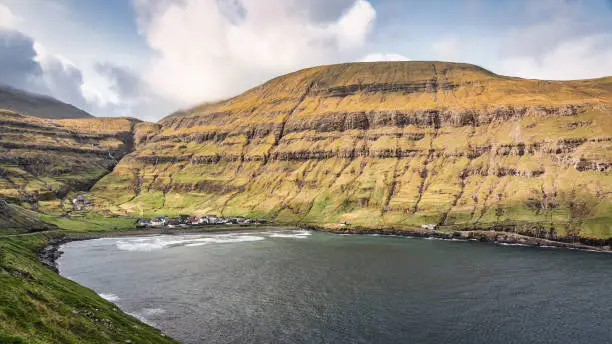 Panorama of Tjornuvik Fjord and Village, the northernmost village on Streymoy in the Sunda Municipality surrounded by tall and green mountain range in summer under beautiful fluffy summer cloudscape. Drone Point of View, Stitched XXL Panorama. Tjornuvik Town and Fjord, Sunda, Streymoy Island, Faroe Islands, Kingdom of Denmark, Nordic Countries, Europe