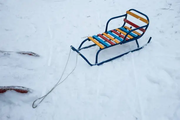 Photo of color wood and metal children sledges on the white snow
