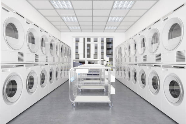 바퀴달린 세탁 바구니가 달린 세탁소에서 흰색 세탁기와 건조기. - 빨래방 뉴스 사진 이미지