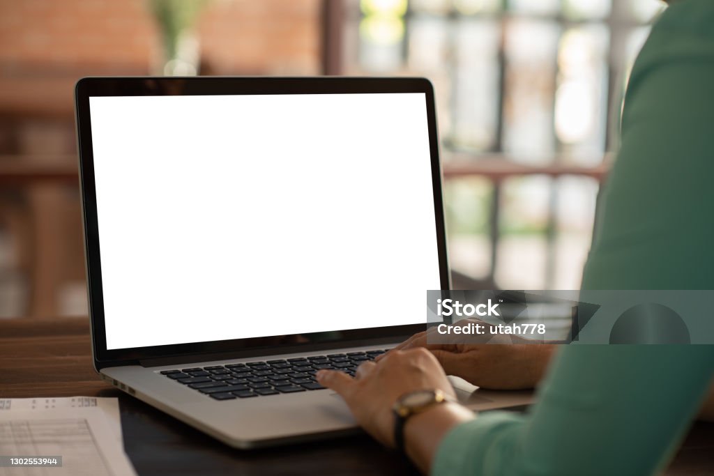 blank white desktop screen computer Mockup image of woman using and typing laptop computer with blank white desktop screen working at home. Women Stock Photo