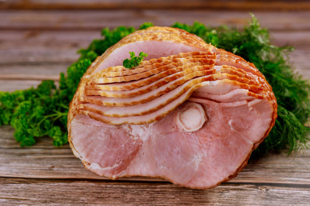istock Pork ham sliced with herb on wooden background. 1302557689