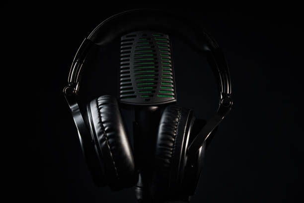 istock Studio microphone and headphones on black background. Online podcast concept 1302558641