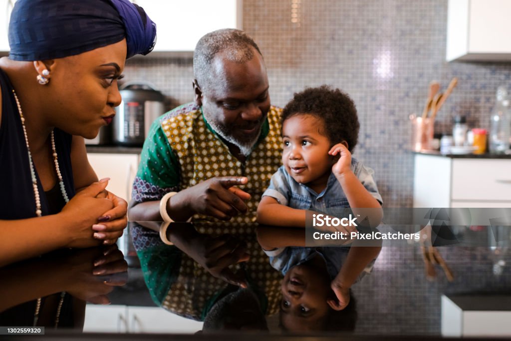 Grands-parents parlant au petit garçon à la table de cuisine - Photo de Grand-mère libre de droits