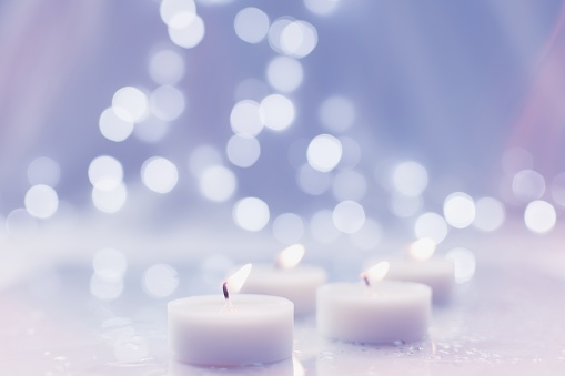Burning tea light candles with bokeh background