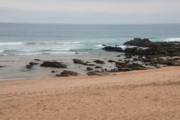 istock Waves Breaking in the Shallows onto Black Rocks 1302561289