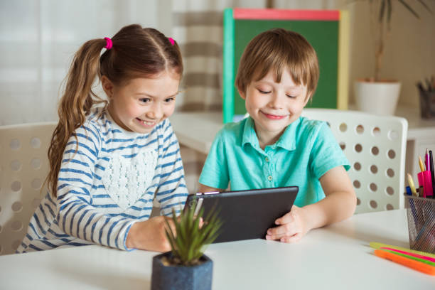 istock Two happy children watch an online lesson.Child uses tablet for learning and communication, and calls their grandparents. Brother and sister play together 1302561426