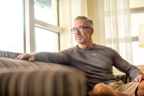 istock Portarit of a handsome older man sitting on a sofa. 1302566193