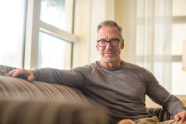 istock Portarit of a handsome older man sitting on a sofa. 1302567191
