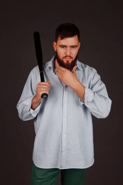 portret brutalnej, brodatej, agresywnej, dużej osoby z kijem baseballowym w ręku na ciemnym tle - bat weapon baseball mob zdjęcia i obrazy z banku zdjęć