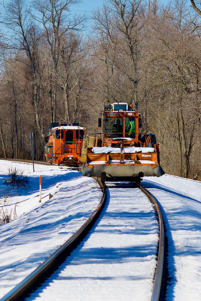 Linden, Virginia / USA - February 8, 2021: Two railroad track maintenance vehicles travel away from the camera on a cold, winter day.