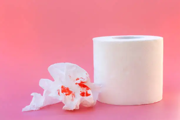 Toilet paper and blood. Concept of hemorrhoid treatment.