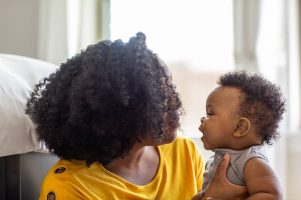 istock Happy mother smiling and playing with her son at home. 1302569335