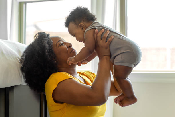 istock Happy mother smiling and playing with her son at home. 1302569406
