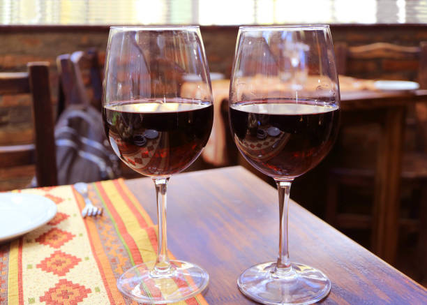 istock Pair of red wine on the wooden table 1302570409