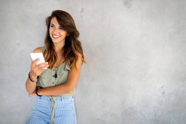 istock Smiling happy beautiful woman using smartphone. Technology, device people concept 1302570414