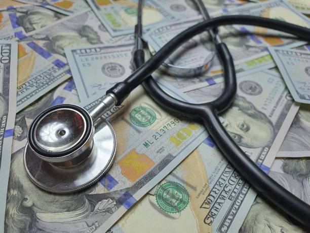istock heap of dollars with stethoscope.Use for website banner background, backdrop, montage. 1302571990