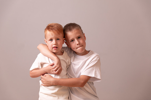 Happy Teenager and Kid Portrait. two brothers. red and blond. small and large boys. friendship between brothers
