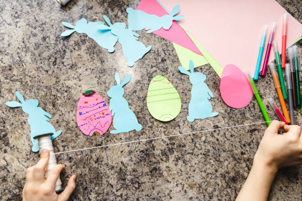 istock Kid Easter preparation by painting Easter eggs and holiday decorations at home closeup 1302574785