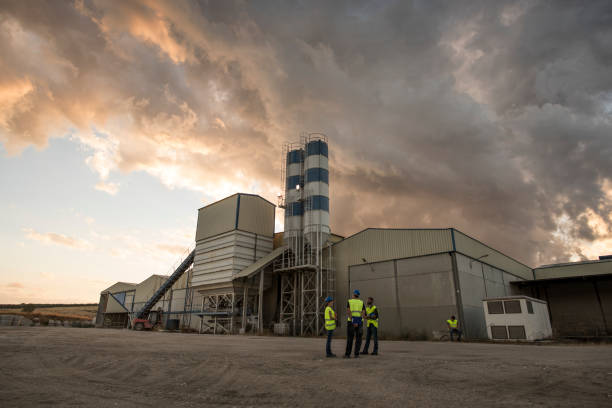 workers in a cement factory work outdoors with a tablet planning their work and checking concrete structures