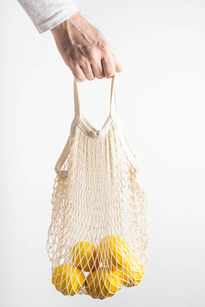 istock A man's hand holds an eco-friendly bag with ripe lemons 1302578886