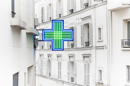 A pharmacy badge on a street in Paris