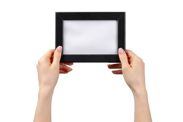 istock Female hands holding photo frame isolated on white 1302581422