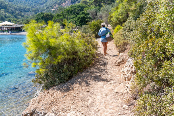 istock Woman walking on the footpath on the beach. 1302582074