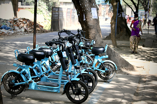 Bangalore or Bengaluru, Karnataka, India-January 15 2021: A group of Yulu Miracle electric bikes or bicycles or scooters or cycles are parked on a road side street for rentals.