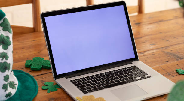 istock Laptop computer on a wooden dining table with shamrock decorations for st patrick's day 1302583153