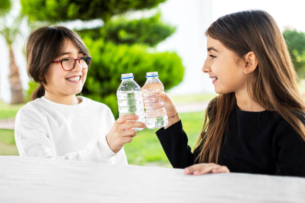 istock Cute little girls drinking water 1302583425