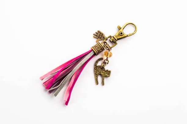 Photo of Fashionable key ring isolated on white, stylish boho jewelry