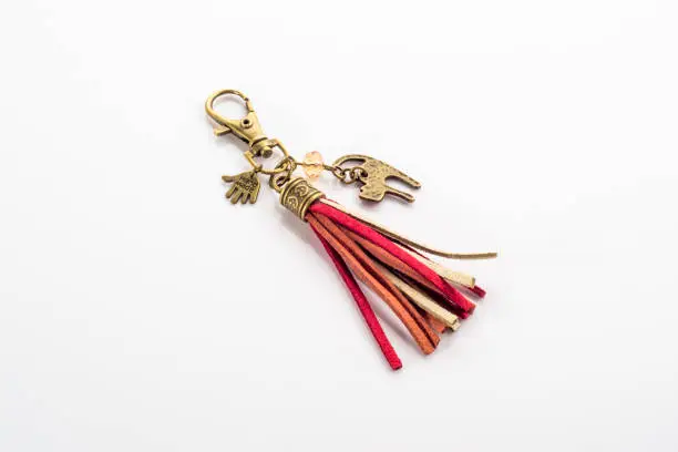 Photo of Fashionable key ring isolated on white, stylish boho jewelry