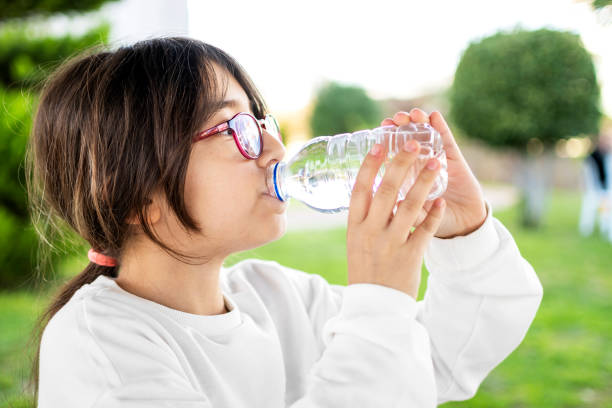 istock Cute little girl drinking water 1302584765