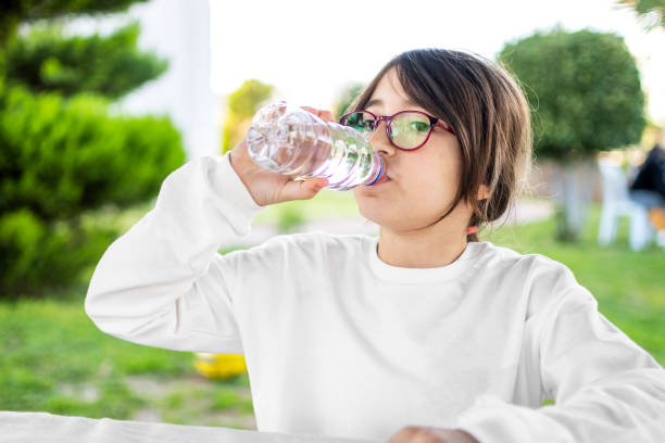 istock Cute little girl drinking water 1302584962
