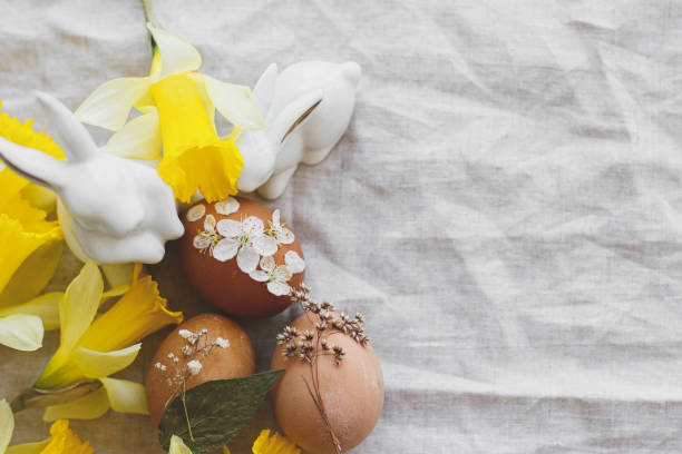 istock Happy Easter flat lay! Easter eggs decorated with dry flower on rustic linen with daffodils, bunnies 1302585011