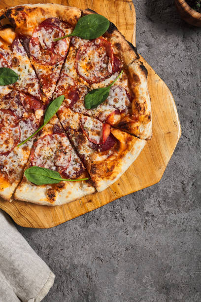 istock Pepperoni Pizza on Wooden Trat with Textile Napkin 1302588164