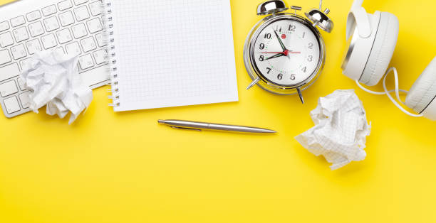 istock Office desk with supplies, alarm clock and blank notepad 1302590761