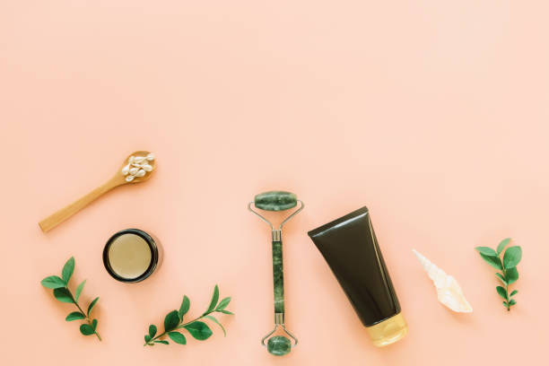 istock Natural cosmetics and face roller on coral colored background. Top view, flat lay, copy space 1302590877