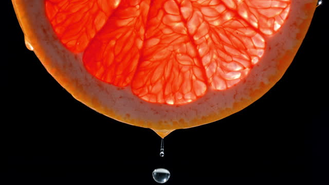 SLO MO LD Waterdrop falling off a slice of grapefruit