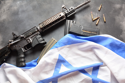 Gun with Israeli flag on the background.