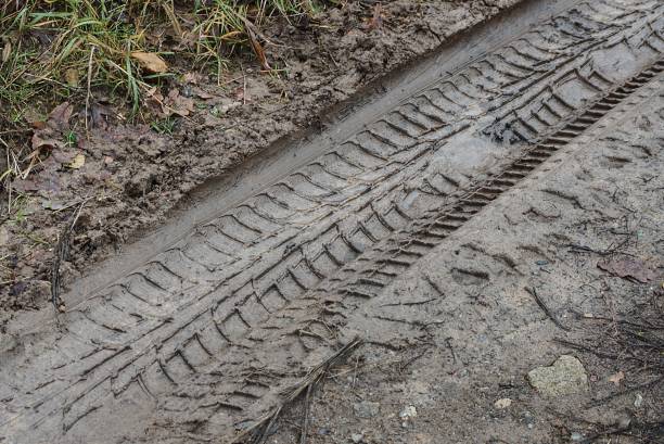 istock gray  texture from a car trail of wet clay 1302594177