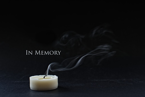 In memory of a loved one. Extinguished candle with smoke.