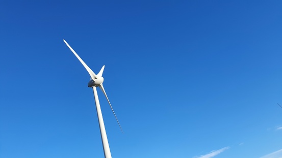 Lone wind turbine against blue sky