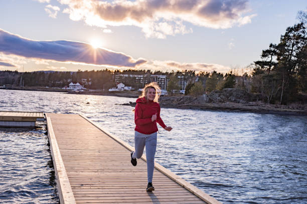 istock Sportswoman running on pier. 1302597046