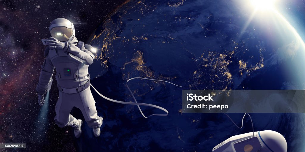 Astronaut On Spacewalk Taking Selfie In Front Of Earth Astronaut connected to a tethered lifeline floats in space, holding up a device to take a selfie with the nighttime city lights of planet earth, as the sun rises. Distant stars and galaxies are visible in the background. Credit: NASA https://earthobservatory.nasa.gov/images/79790/city-lights-of-asia-and-australia and ESO for background images. Astronaut Stock Photo